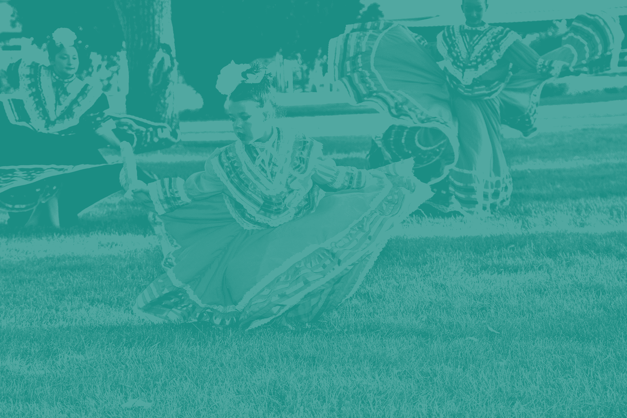 Young folklórico dancers in full ruffled skirts dance on the grass, in a one-color teal print